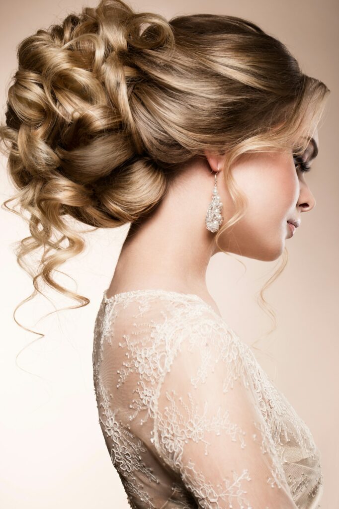 Beautiful bride with fashion wedding hairstyle - on beige background.